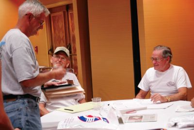 Vehile Registration table 
Seated are Warren Ramsey and Bob Norton, standing is Randall Crain
