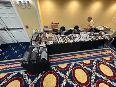 Long time Member & Vendor Gene Guarnere with Merchandise in the Hospitality Room
