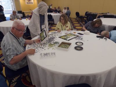 Members enjoying the A/C in the ROA Hospitality Room …
Using the time to work on the crossword puzzle
